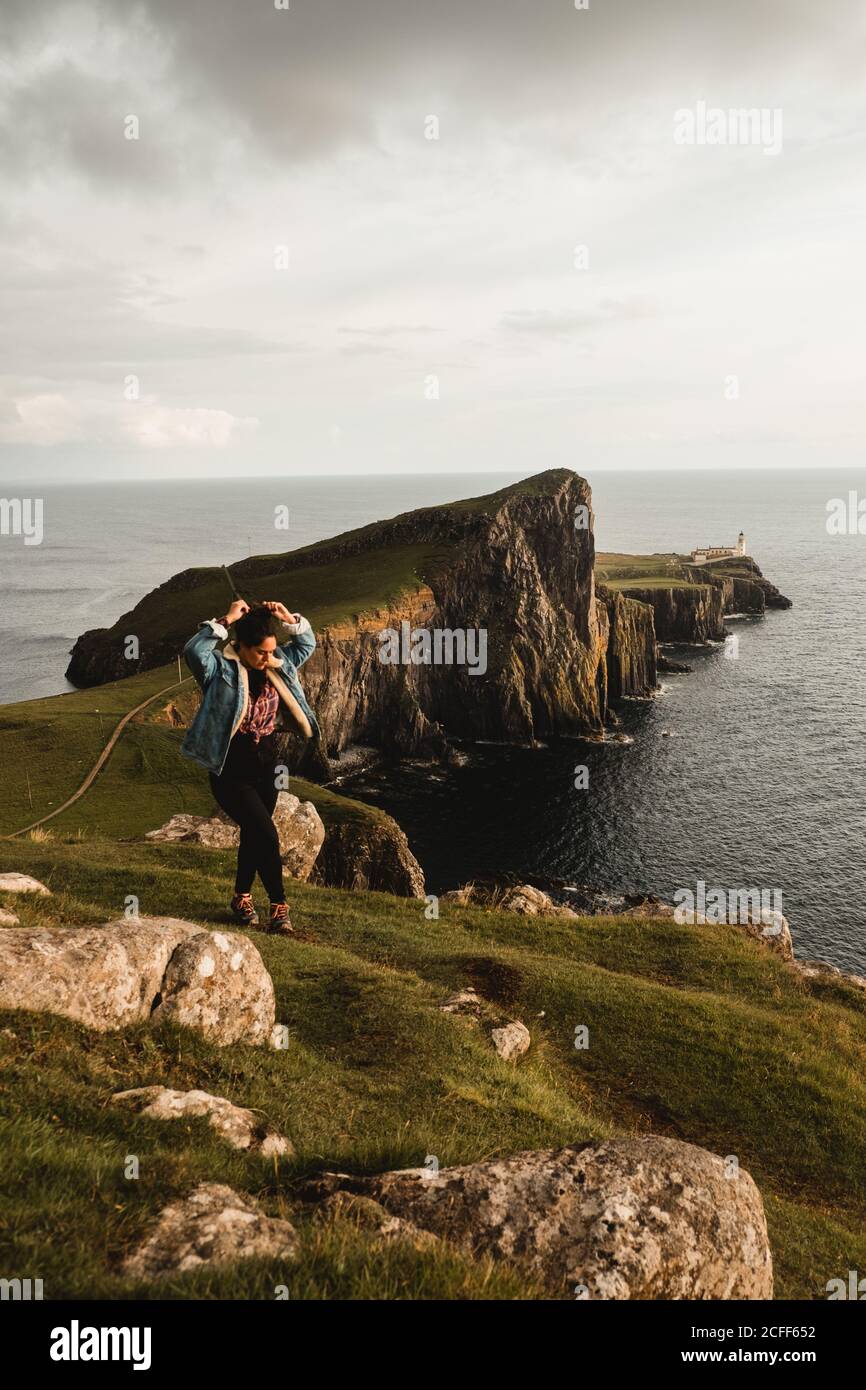 Escursione turistica lungo il torrente in prato contro la montagna in nuvole Foto Stock