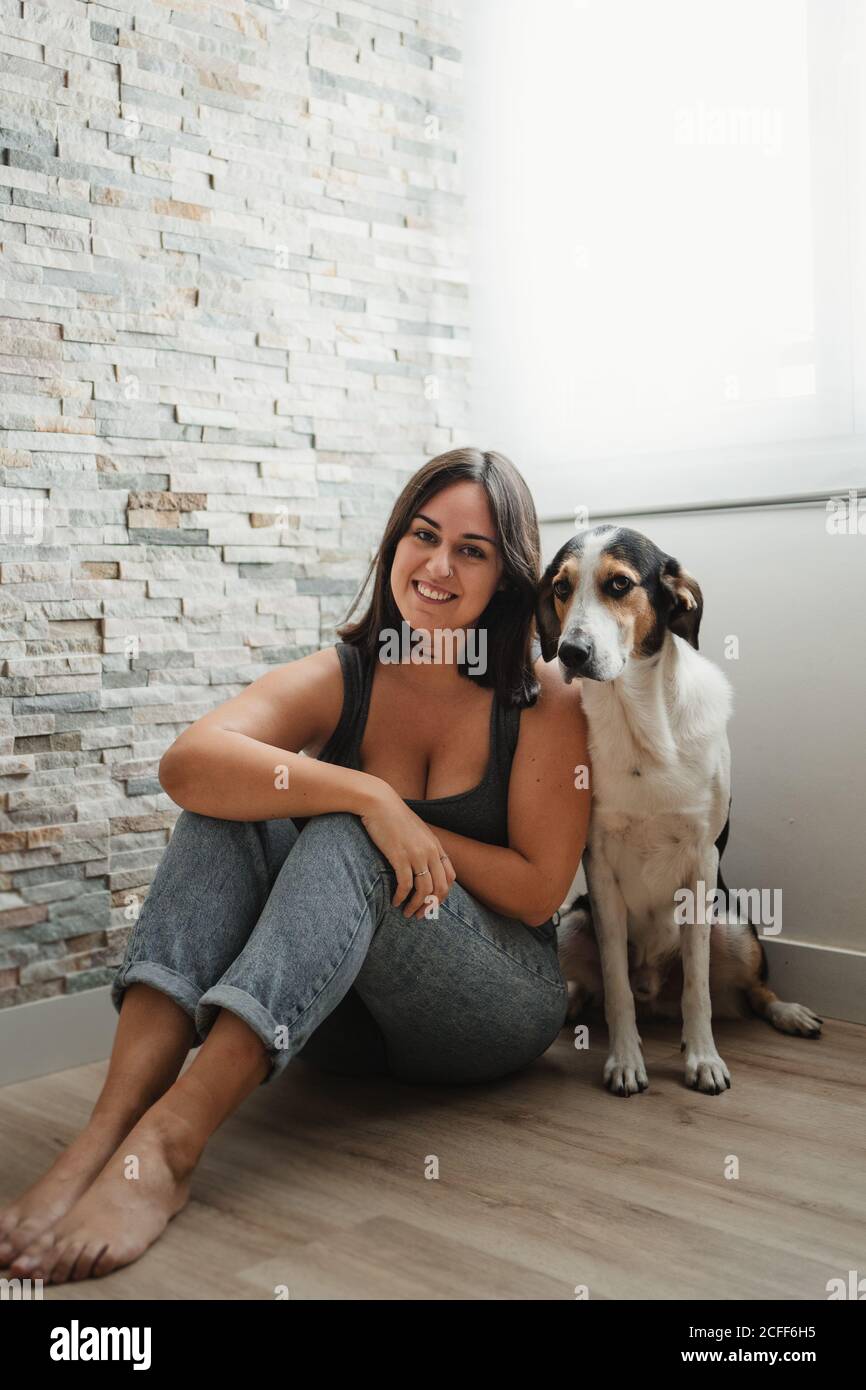 Donna con cane seduto sul pavimento Foto Stock