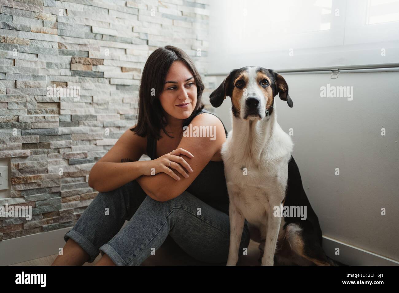 Donna con cane seduto sul pavimento Foto Stock
