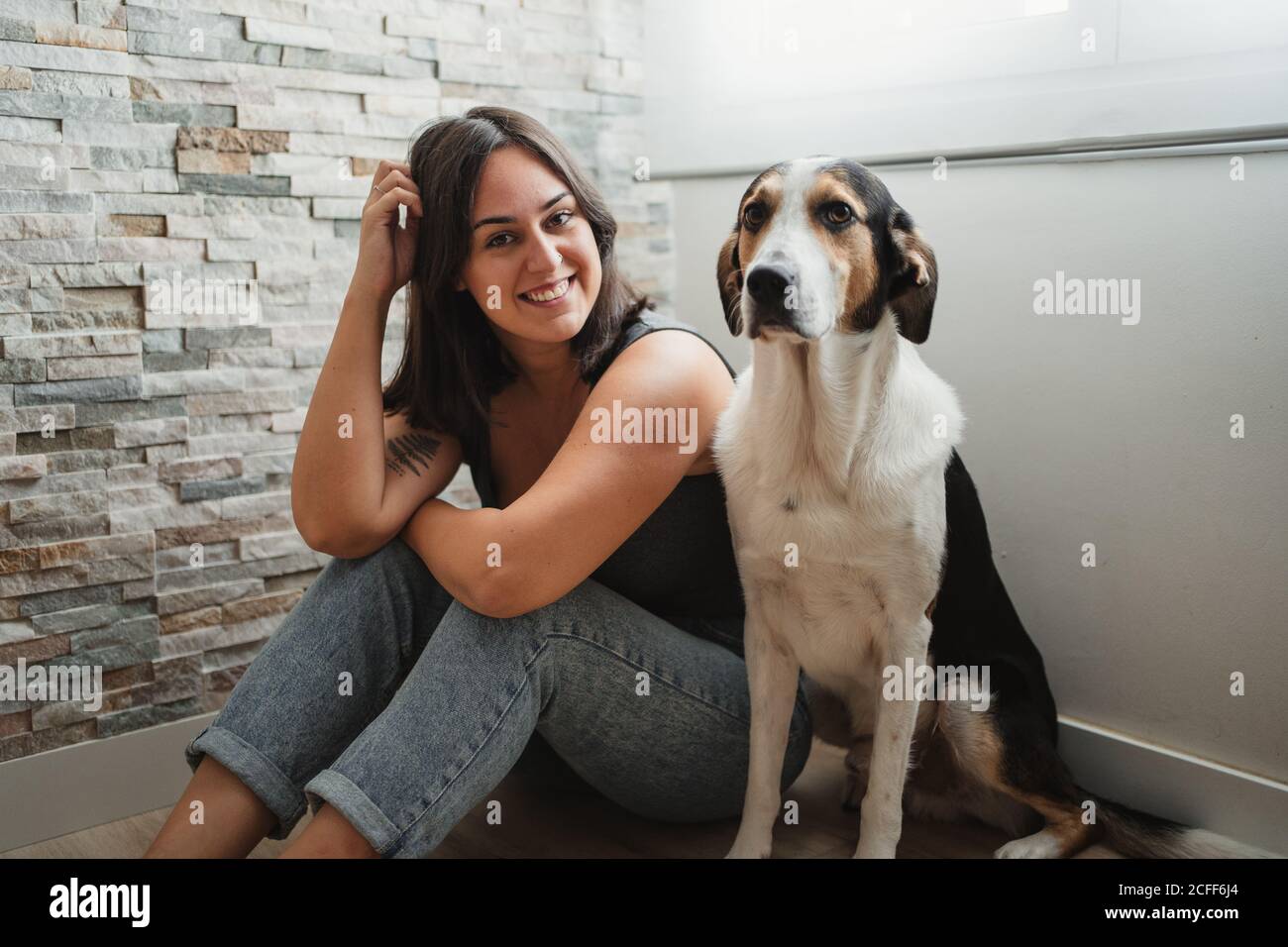Donna con cane seduto sul pavimento Foto Stock