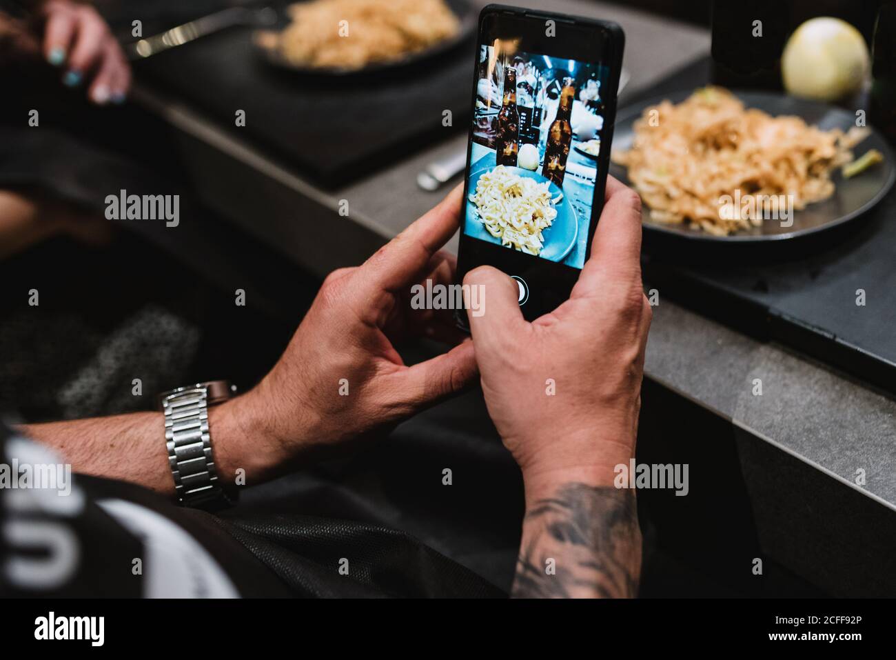 Da sopra persona irriconoscibile che usa lo smartphone per scattare foto di un piatto gustoso dopo la lezione in laboratorio di cucina a Navarra, Spagna Foto Stock