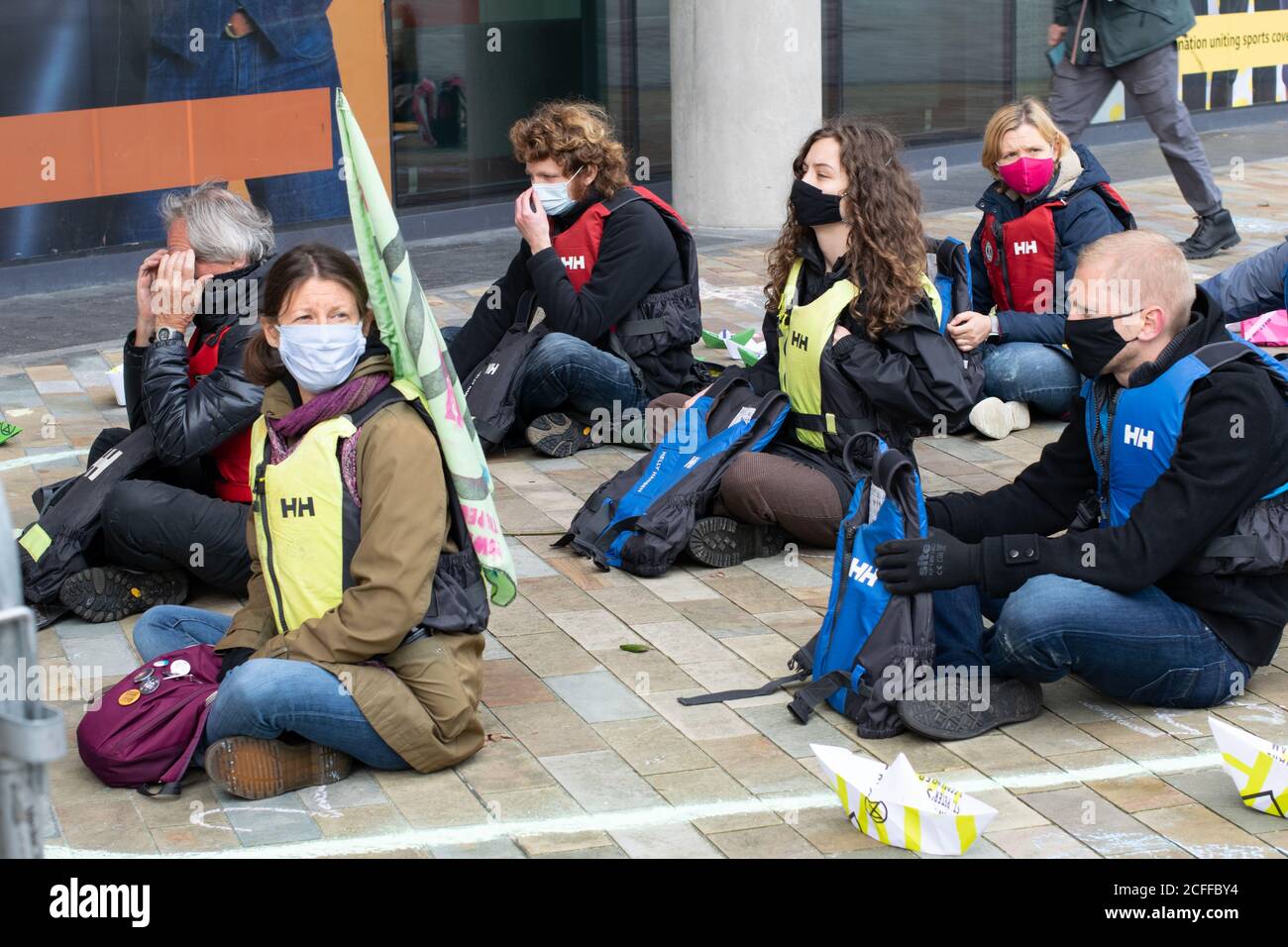 La ribellione dell'estinzione libera la verità protesta a Media City, Manchester UK. Manifestanti in un profilo gesso di una barca che rappresenta i rifugiati climatici. Foto Stock