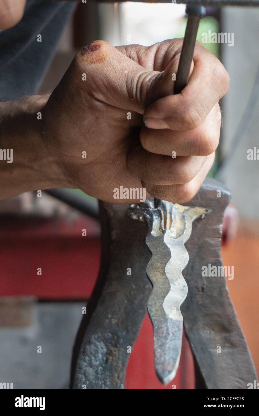 Fare i tradizionali keris balinesi manualmente. Il processo di intagliatura dei dettagli balinesi del keris è un po' complicato e meticoloso Foto Stock