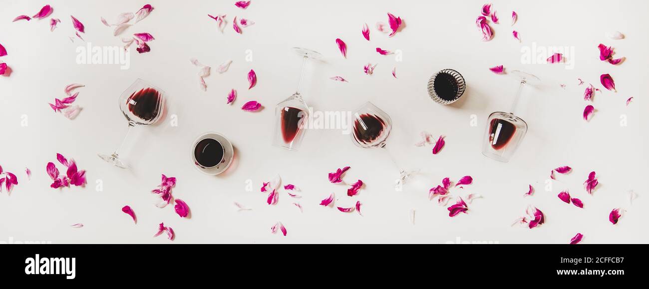 Piatto di bicchieri con vino rosso e petali di fiori rosa Foto Stock