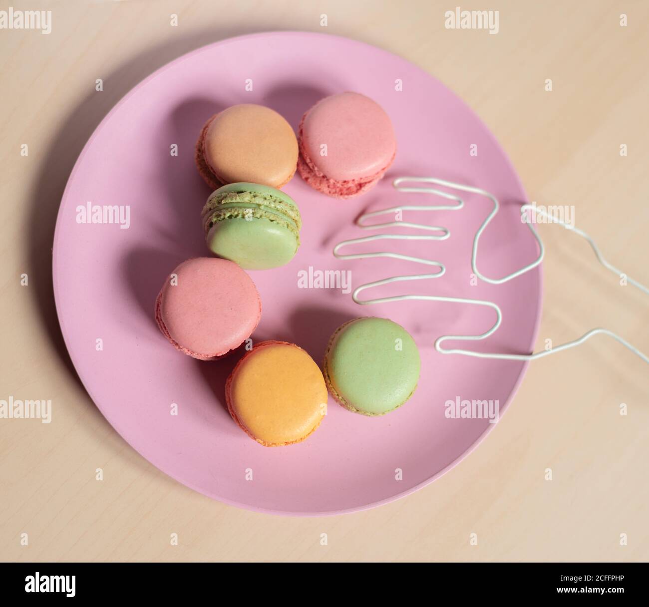 Dall'alto di deliziosi biscotti colorati macaron disposti in forma di emoji sorriso Foto Stock