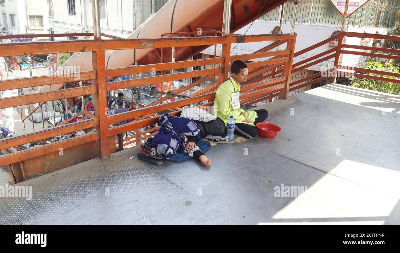 Un mendicante cieco sta mendicando al ponte dei piedi. Madre sta mentendo accanto a lei. Povero figlio, povera madre foto. Foto Stock