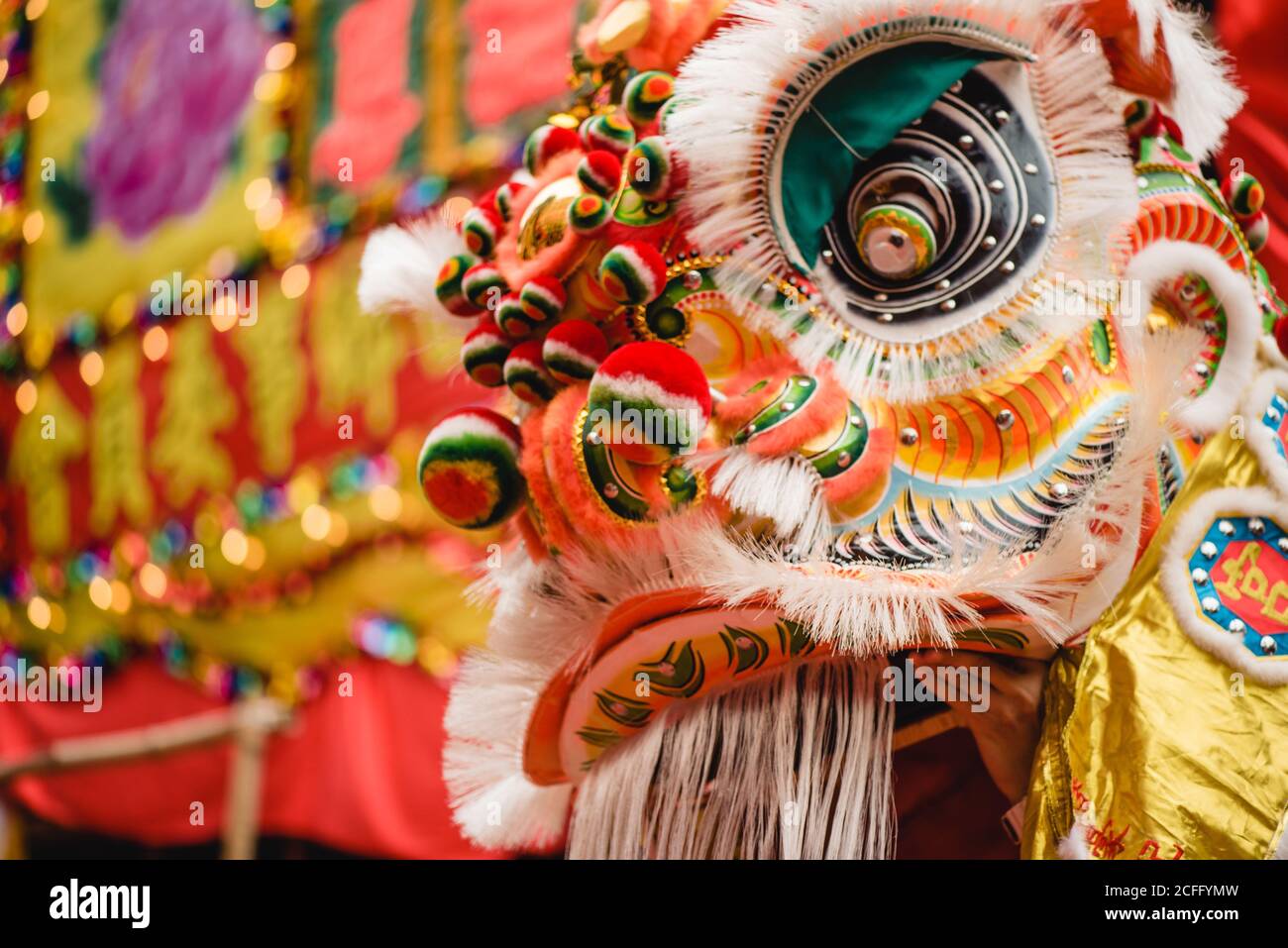 persona anonima che indossa un costume ornamentale colorato di drago mentre si esibisce Danza tradizionale del Drago Foto Stock