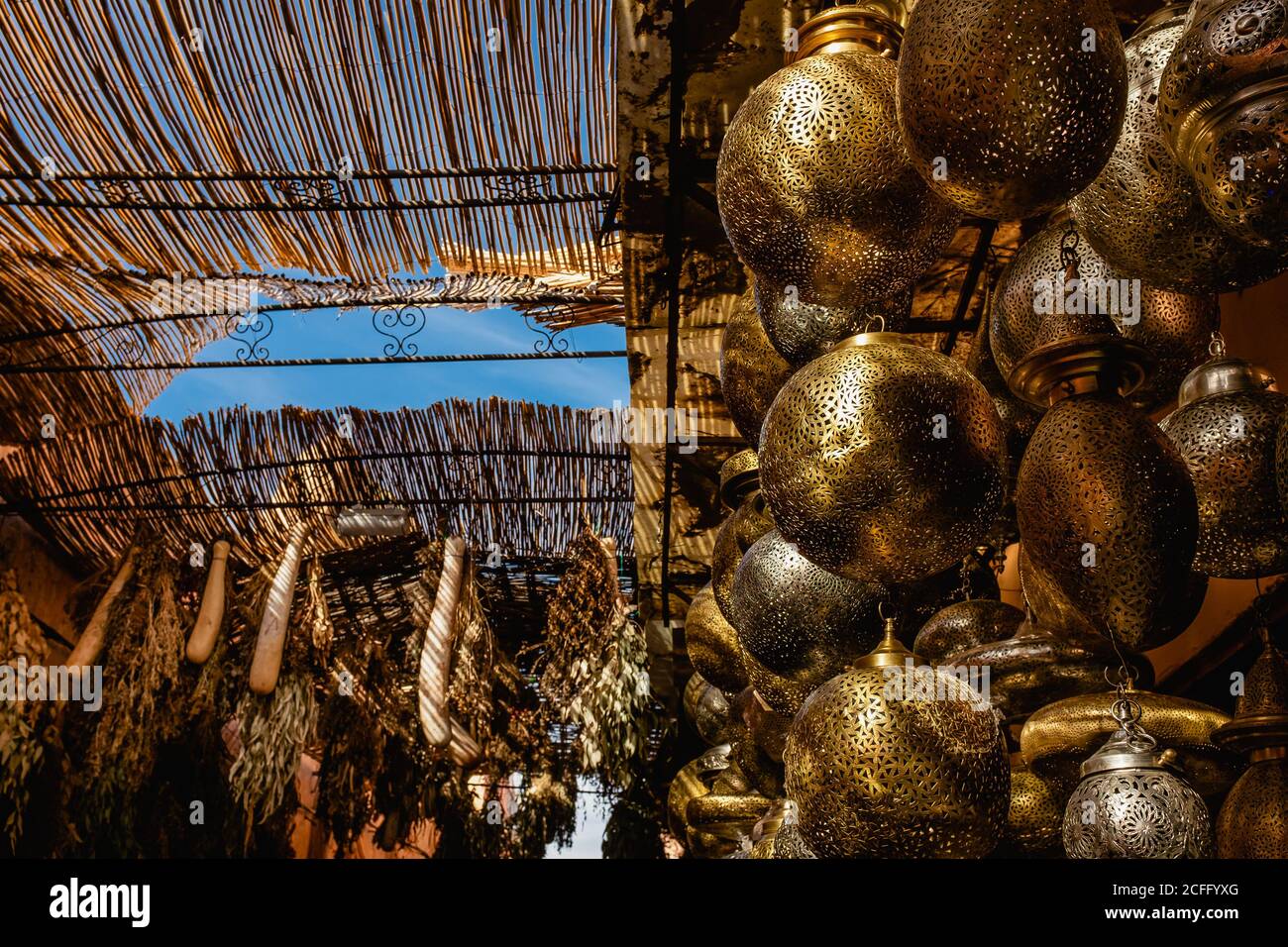 Basso angolo di bazaar marocchino locale con tradizionali lampade a sospensione e piante secche in vendita Foto Stock