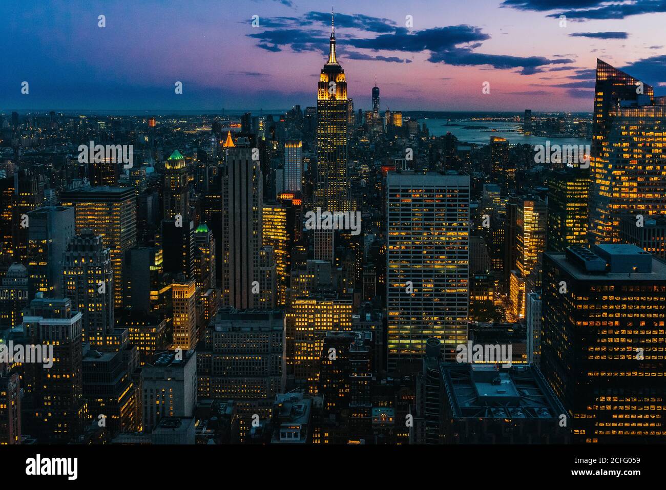 Vista aerea di megalopoli con pareti di vetro illuminate e futuristico facciate di alti grattacieli sullo sfondo di un maestoso tramonto Foto Stock