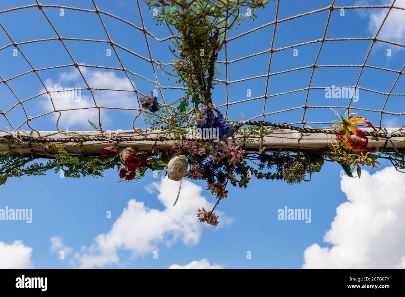Rete decorata con fiori artificiali contro un cielo blu Foto Stock