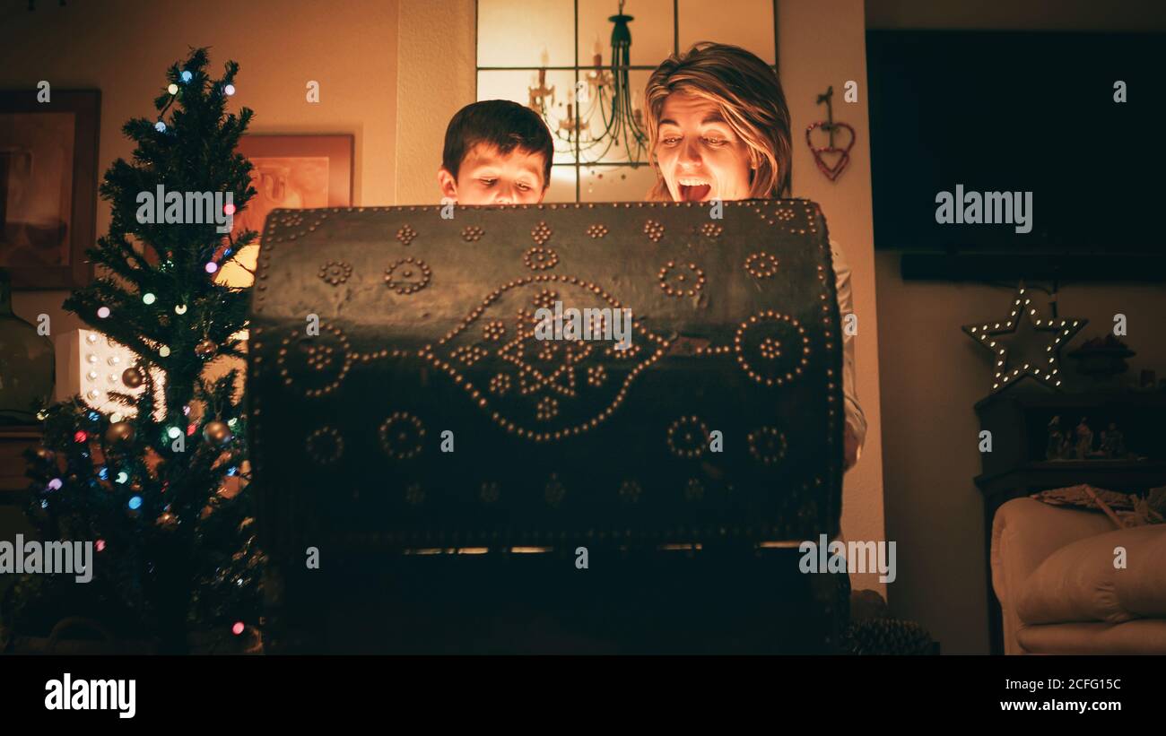 Madre e figlio aprono la cassa magica il giorno di Natale Foto Stock