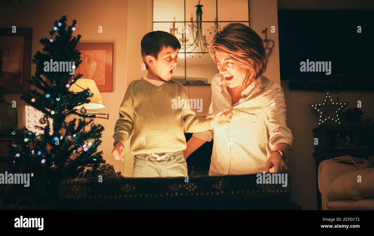 Madre e figlio aprono la cassa magica il giorno di Natale Foto Stock