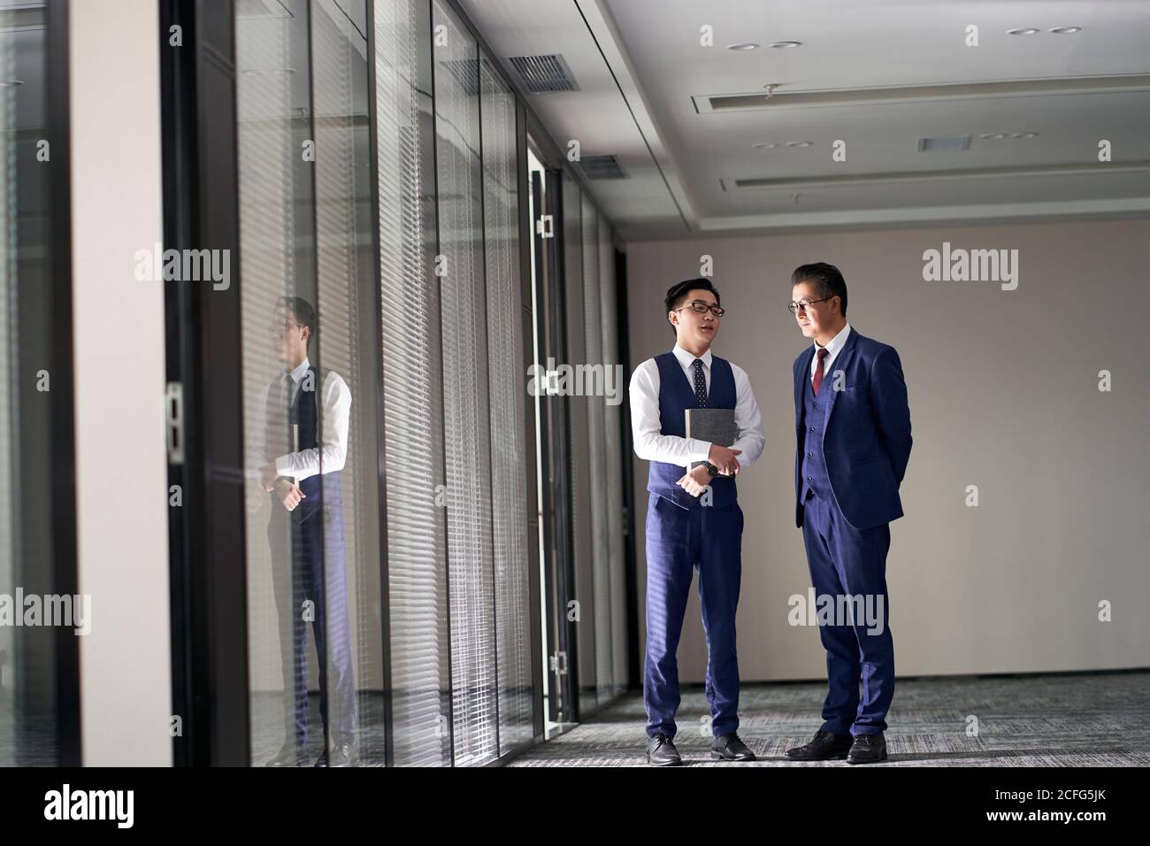 due dirigenti aziendali asiatici in carica discutono di affari Foto Stock