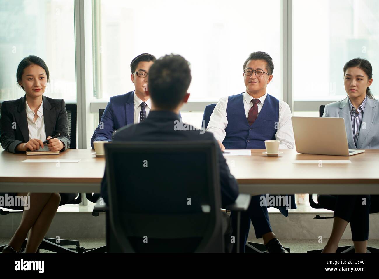 giovane uomo d'affari asiatico intervistato da un gruppo di dirigenti delle risorse umane aziendali Foto Stock
