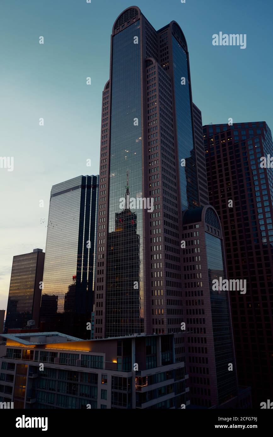 Da sotto grattacieli moderni con cielo blu sullo sfondo al tramonto a Dallas, Texas USA Foto Stock