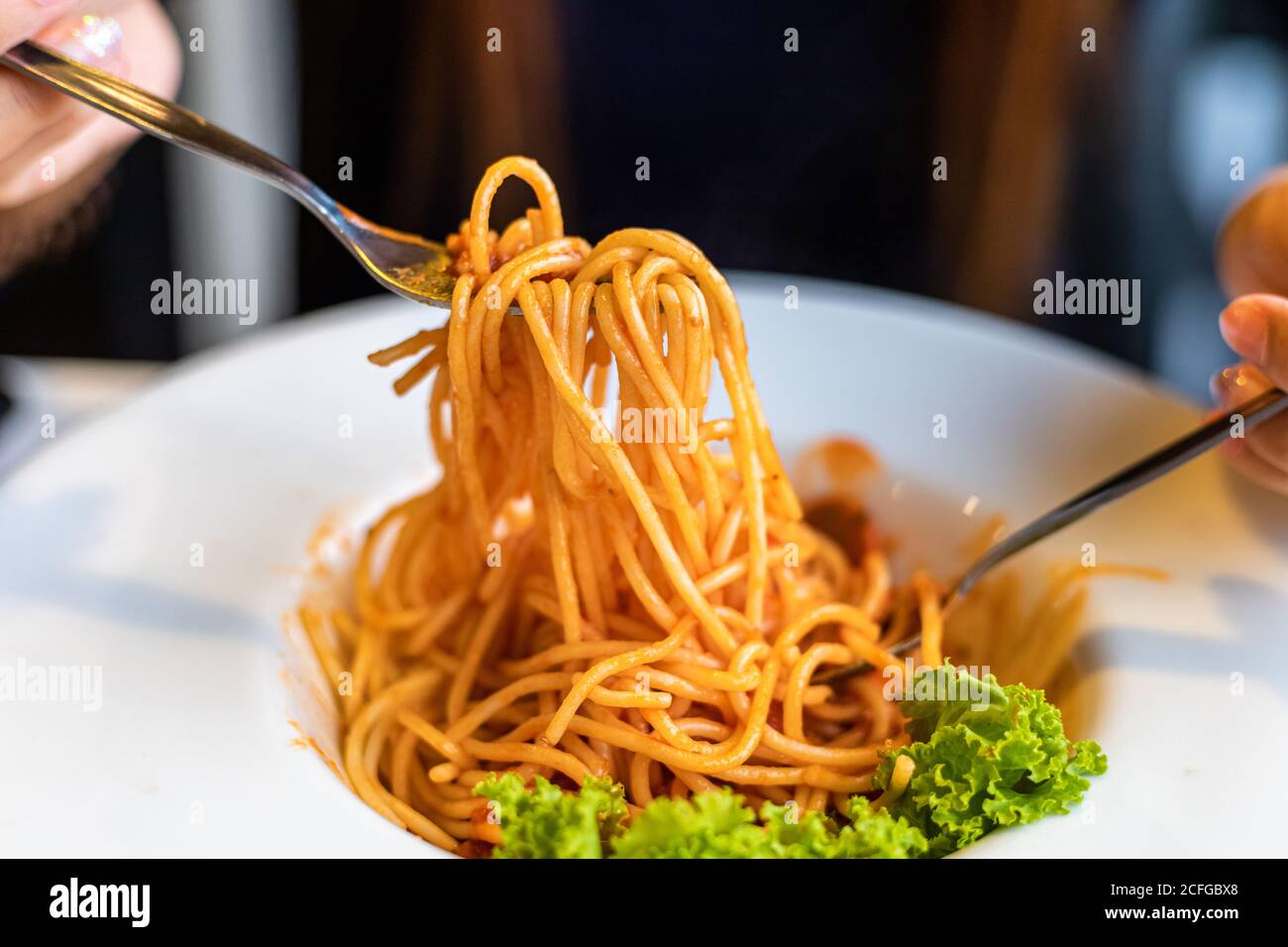 Spaghetti su una forchetta. Ragazza uso forchetta con spaghetti. Pasta con  salsa rossa Foto stock - Alamy