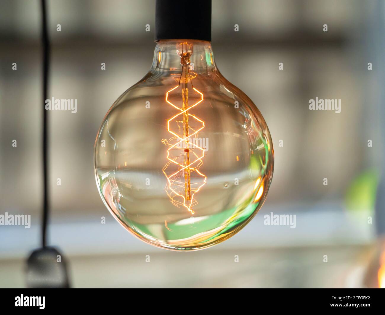 La lampadina decorativa vintage Edison con filamento LED diffonde una luce soffusa e riposante nella stanza Foto Stock