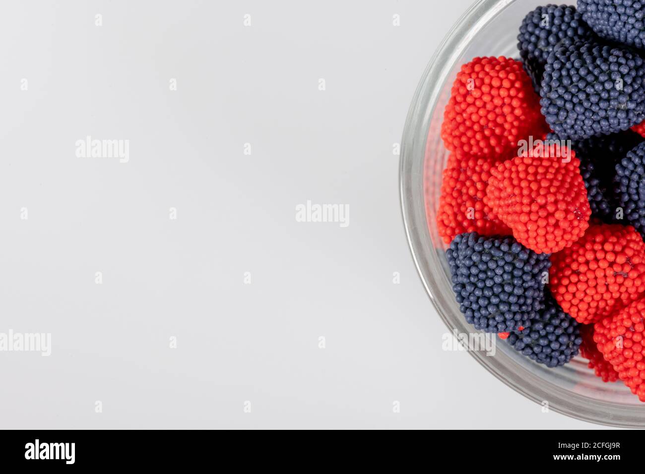 Bordo del recipiente di vetro con caramelle gommosi rosse e blu Foto Stock