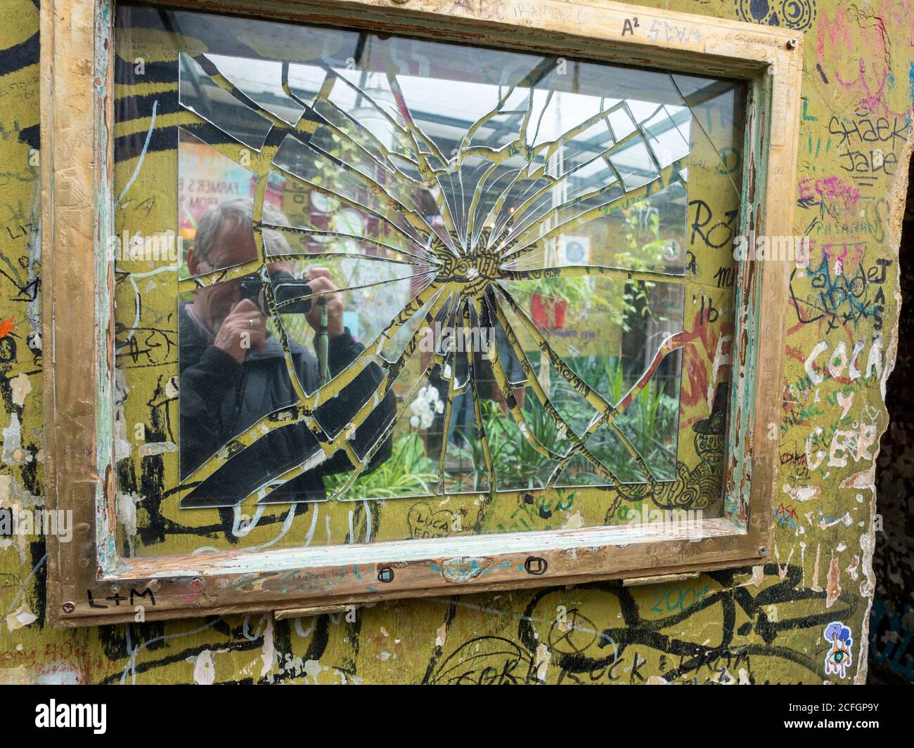 Broken Mirror selfie: Un fotografo scatta una foto di se stesso in un pezzo d'arte malamente rotto, ma pieced insieme nel Ruin Bar di Szpla Foto Stock