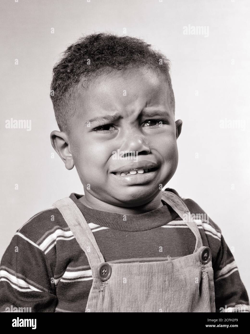 ANNI '40 ANNI '50 RITRATTO INFELICE AFROAMERICANO BAMBINO PIANGENDO GUARDANDO MACCHINA FOTOGRAFICA CHE INDOSSA TUTE CORDUROSE A MAGLIA A RIGHE - N601 HAR001 HARS PAURA COMUNICAZIONE PREOCCUPAZIONE STILE DI VITA STRIPED MOODY LACRIME VITA A CASA TEE COPIA SPAZIO TUTE GRIDARE MASCHI TEMONO ESPRESSIONI TORMENTATO B & W TRISTEZZA PREOCCUPATA PIANGENDO TESTA E SPALLE AFROAMERICANI CAVERANNI AFROAMERICANI NERI ETNIA SCONGORANTE UMORE SOBING GLUM BAMBINO RAGAZZO CRESCITA GIOVANI MISERABILI NERO E BIANCO HAR001 VECCHIO STILE AFROAMERICANI Foto Stock
