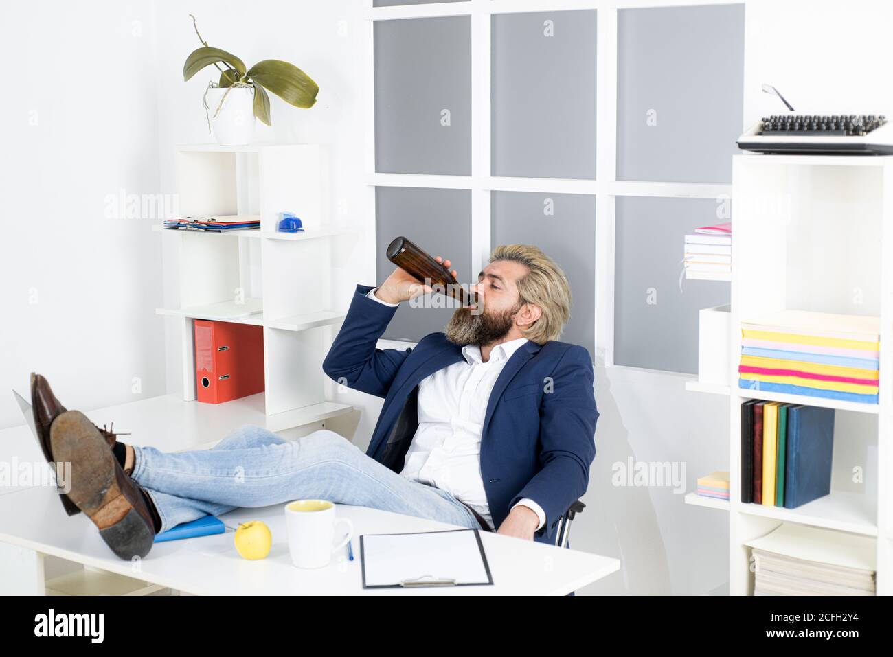 Triste uomo d'affari finito giorno di lavoro con l'alcol. Uomo d'affari ubriaco. Foto Stock