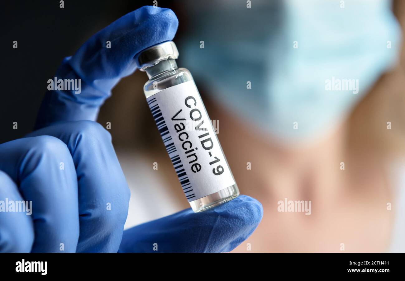 Il medico tiene in laboratorio il flacone con il vaccino COVID-19. Ricercatore femminile e virus corona vaccino per la cura COVID. Concetto di medicina, tria clinica Foto Stock