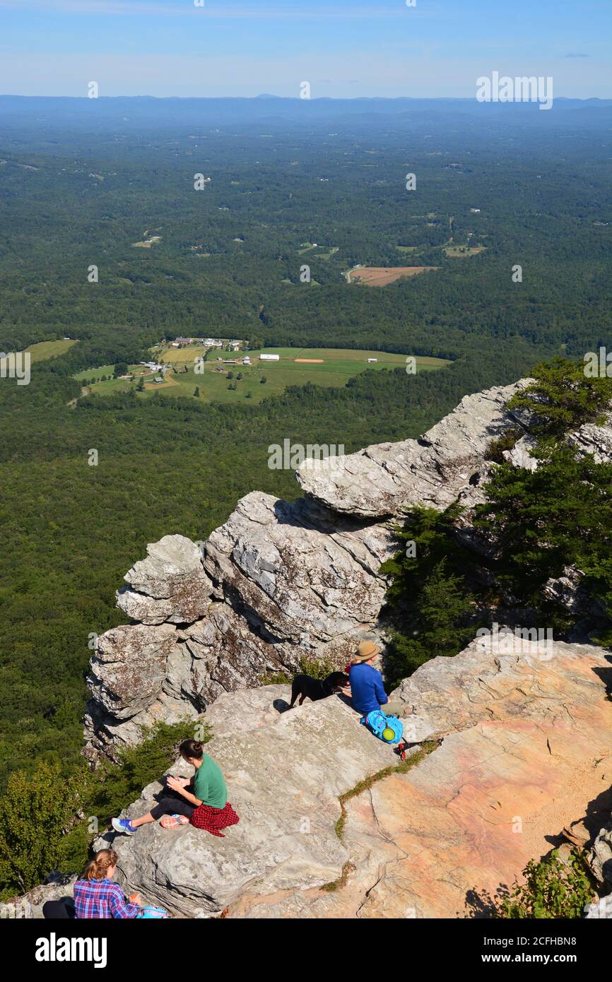 Gli escursionisti si riposano e si ammira la vista della valle circostante in cima a Moore's Knob all'Hanging Rock state Park, nella Carolina del Nord. Foto Stock