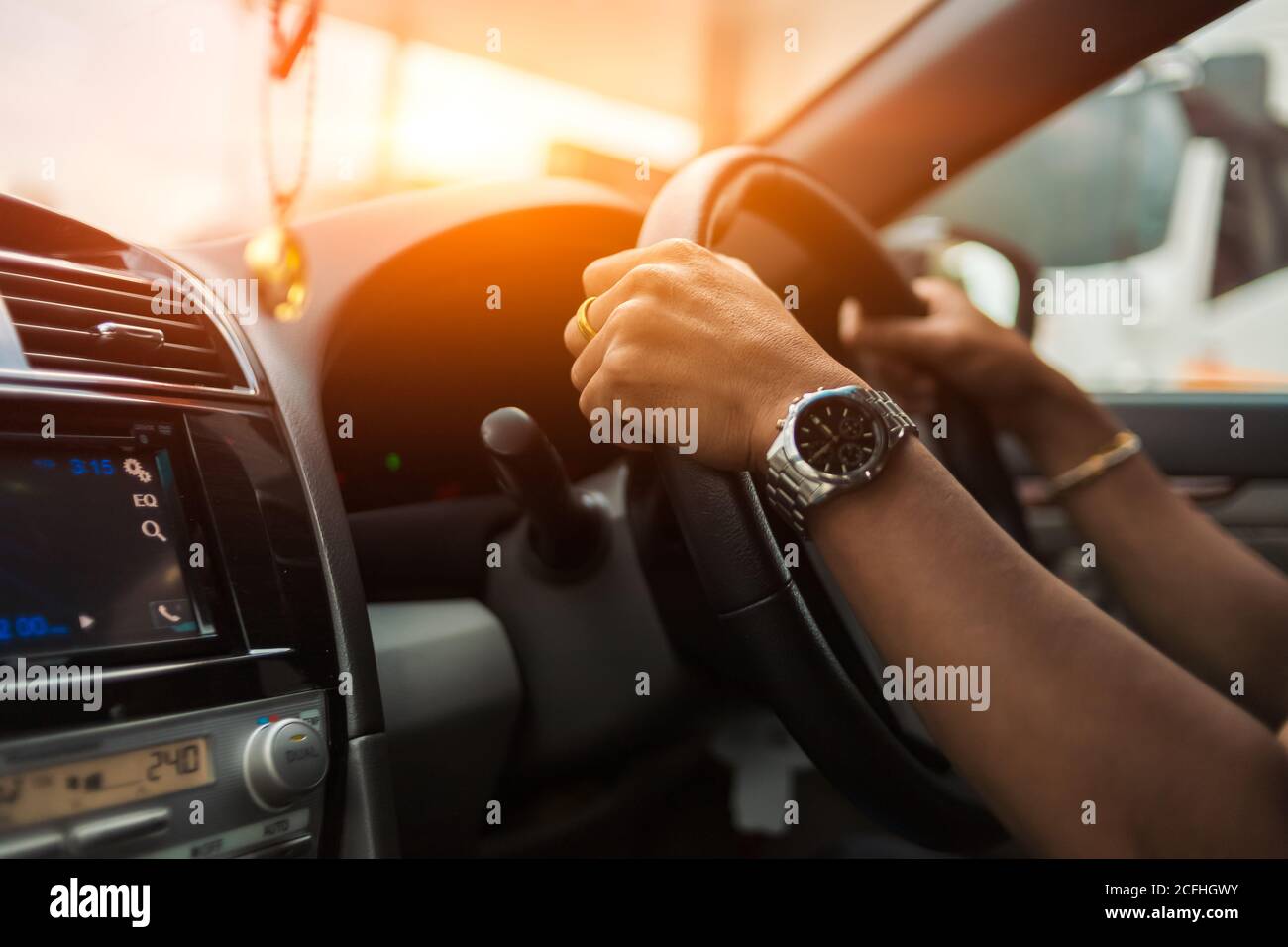 l'uomo a mano indossa un orologio e guida un'auto Foto Stock