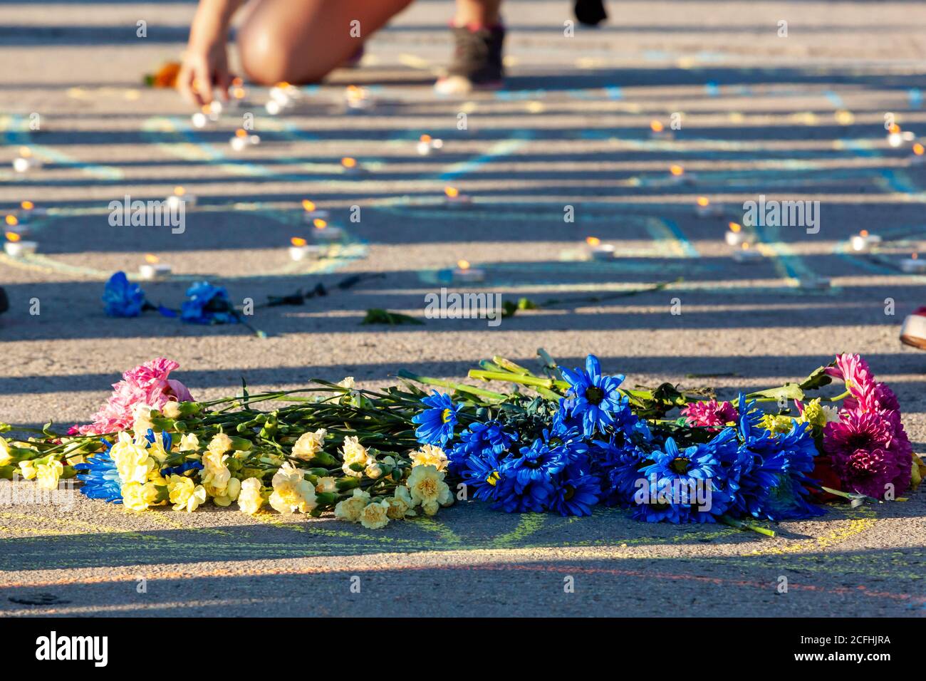 Washington, DC, USA, 5 settembre 2020. Nella foto: Fiori messi in memoria di Deon Kay come una donna accende l'ultima delle candele nel suo nome sul Ponte chiave di Francesco Scott durante la marcia per la giustizia nella sua memoria. Deon Kay era un adolescente ucciso dalla polizia metropolitana (DC) all'inizio della settimana. L'uccisione è controversa perché la polizia ha rilasciato resoconti contraddittori dell'uccisione. Credito: Allison C Bailey/Alamy Foto Stock