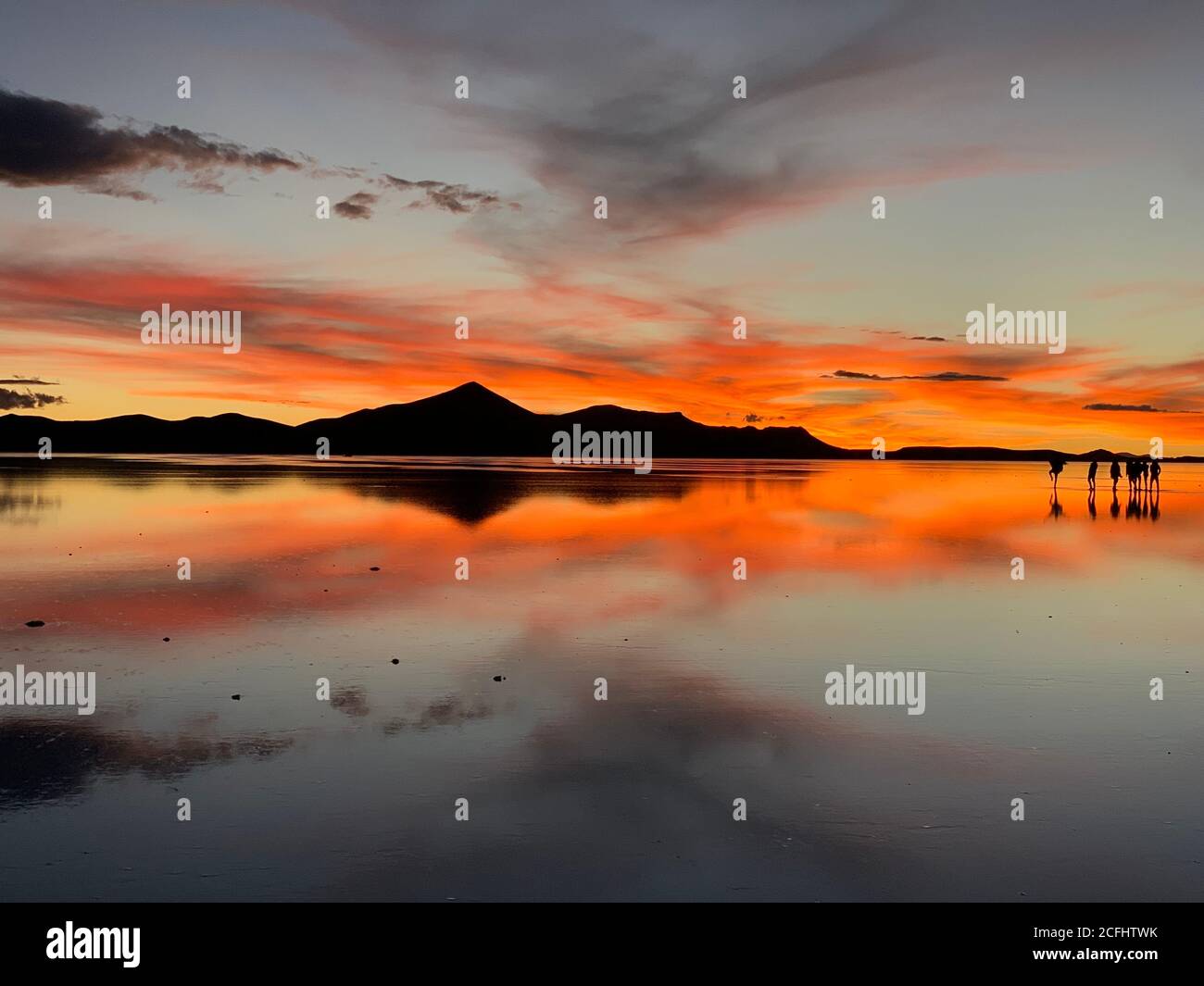 Spettacolare caduta notturna rossa. Tramonto mozzafiato. Cielo di tramonto spettacolare sopra il lago salato a Salar de Uyuni, Bolivia. Incredibile riflesso del cielo in acqua. Foto Stock