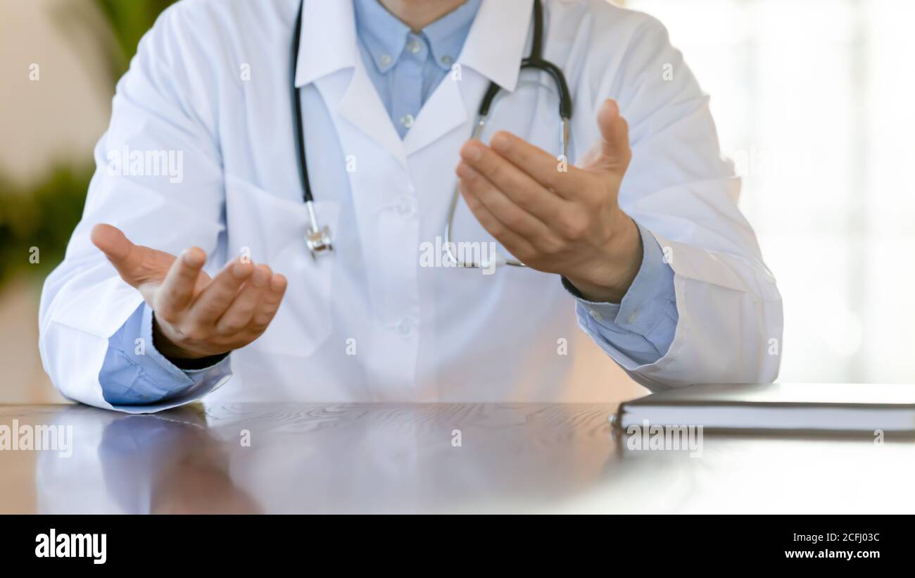 Primo piano medico terapista che consulta il paziente, seduto al tavolo Foto Stock