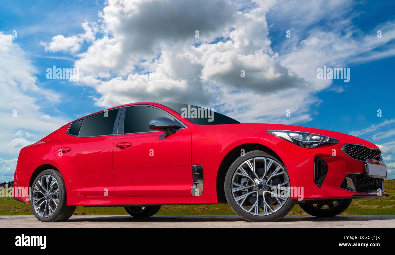 Moderna auto di lusso rossa sotto il cielo nuvoloso Foto Stock