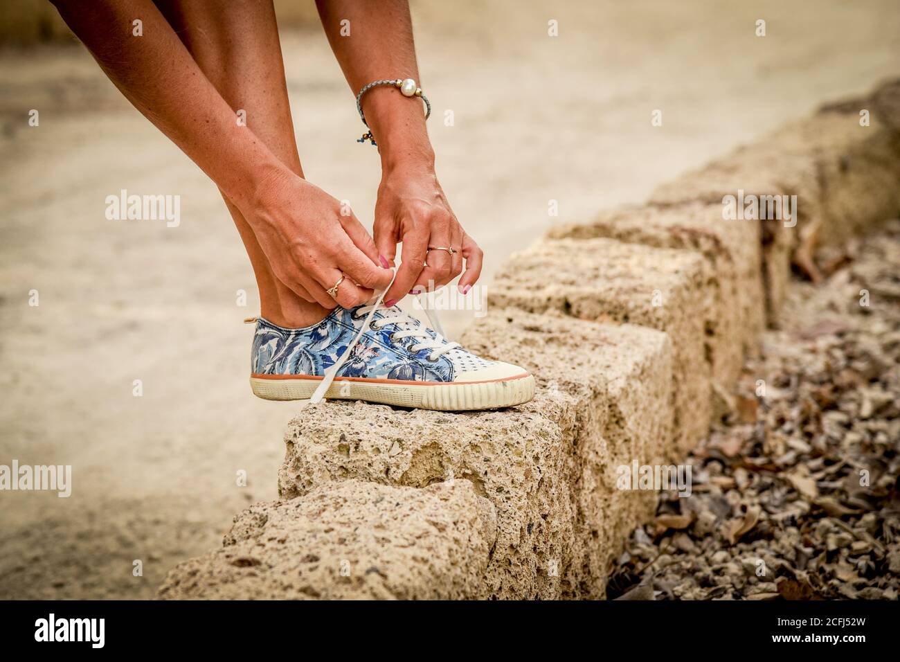 Primo piano di una donna che legava le sue scarpe Foto stock - Alamy