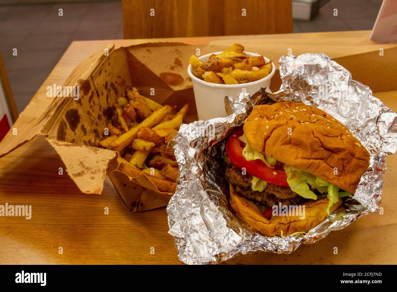 Hamburger e patatine standard "Five Guys" acquistati nella filiale di Cambridge della catena americana di hamburger. Foto Stock