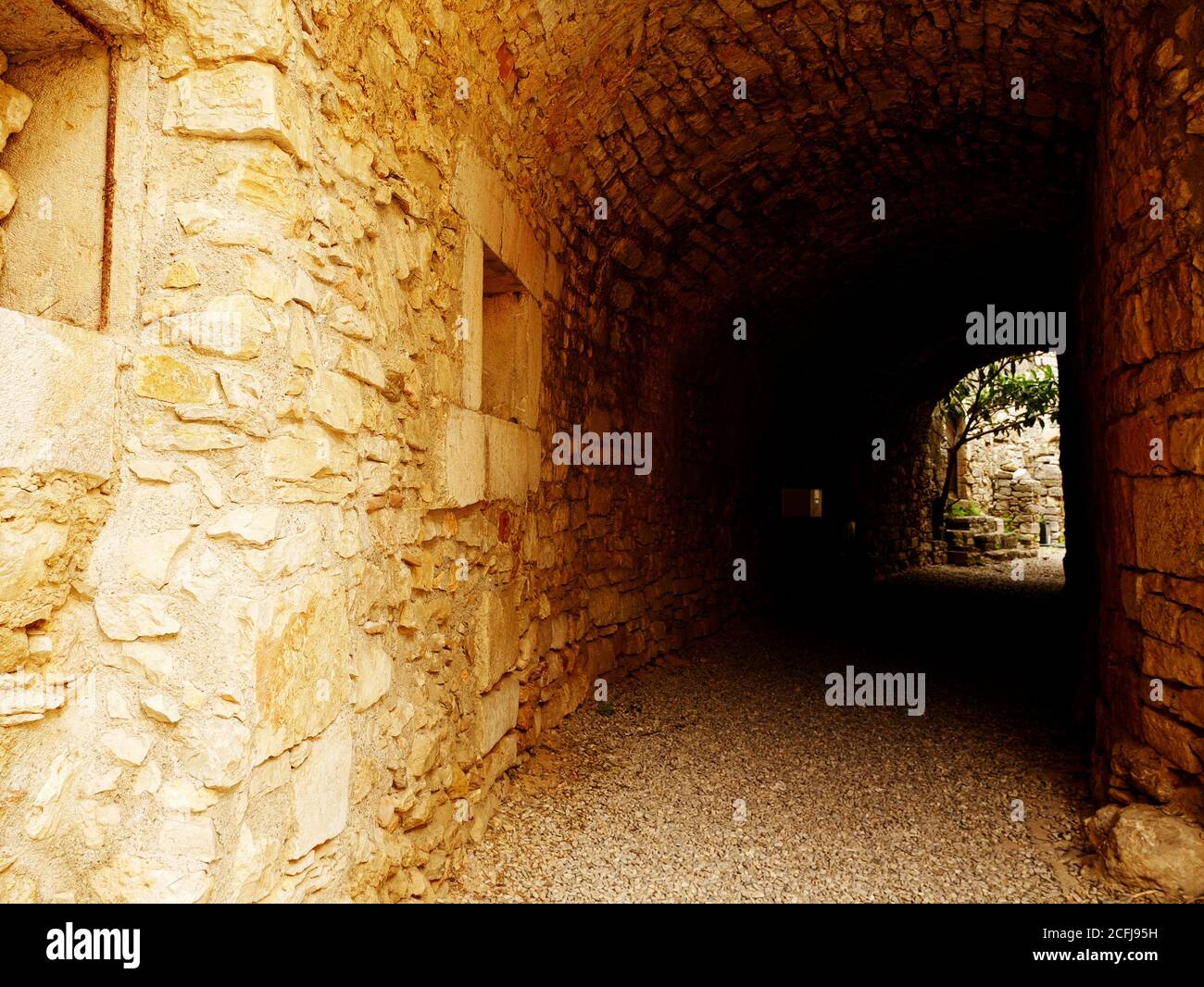 Corridoio scuro all'esterno in pietra in un vecchio villaggio Foto Stock