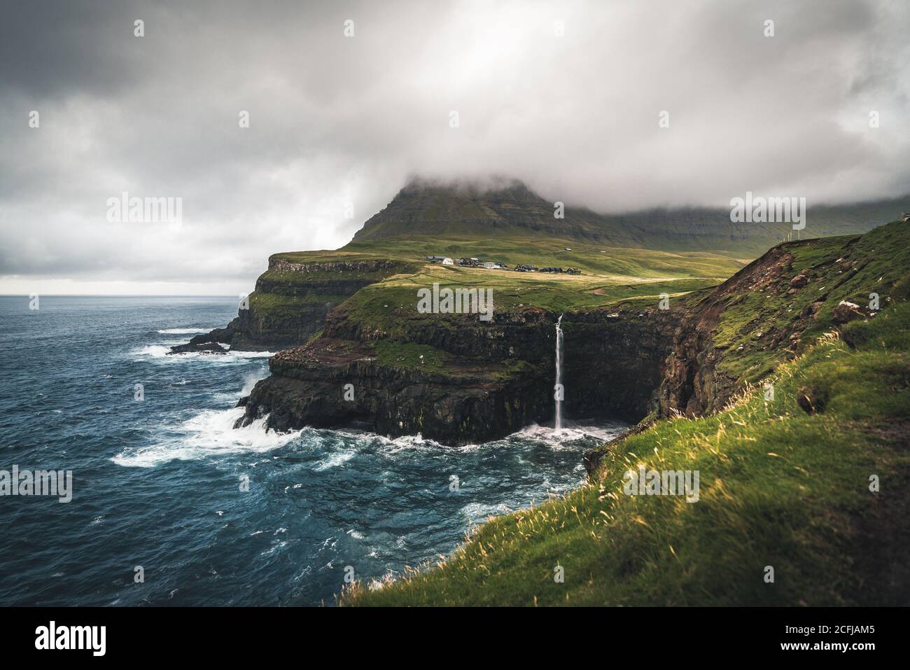 Panorama del drone aereo del villaggio di Gasadalur e Mulafossur la sua cascata iconica, Vagar, Isole Faroe, Danimarca. Vista approssimativa nell'oceano atlantico settentrionale Foto Stock