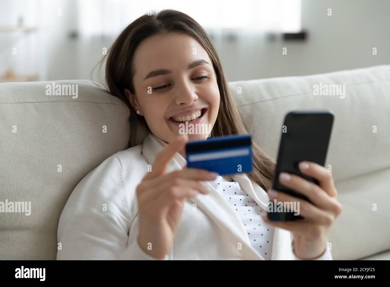 Felice giovane donna che verifica l'acquisto nell'app mobile. Foto Stock