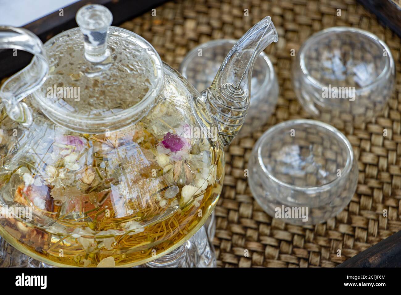 Tisane di fiori secchi, primo piano. Una teiera e una tazza con fiori di tè sul tavolo. Foto Stock