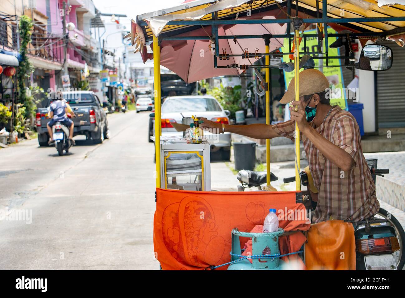 SAMUT PRAKAN, THAILANDIA, Apr 19 2020, un uomo con una cucina mobile su un carrello da una moto offre cibo per la strada. Foto Stock