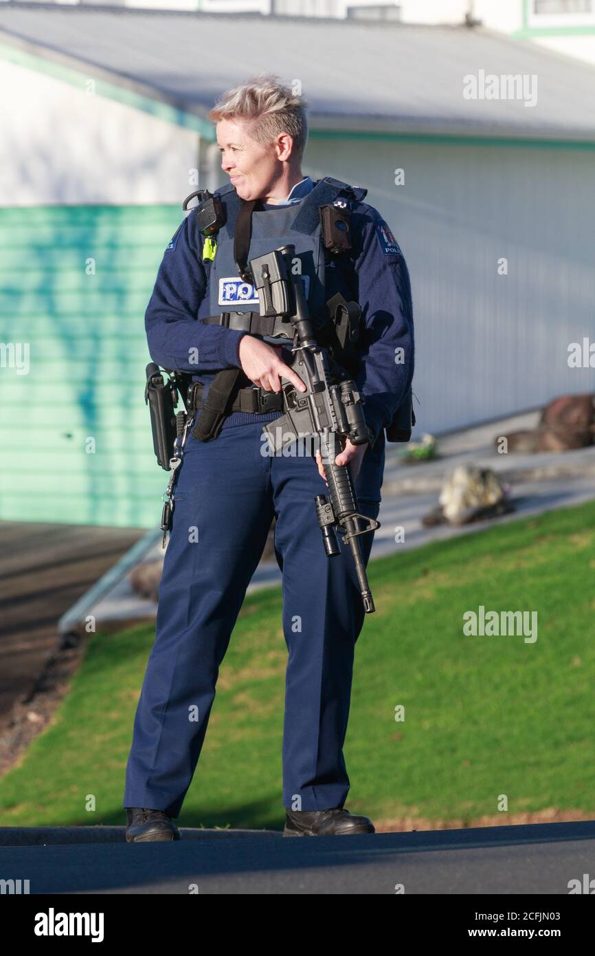Una donna della polizia neozelandese in piedi guardia sulla strada con un fucile d'assalto. Tauranga, Nuova Zelanda, giugno 22 2018 Foto Stock