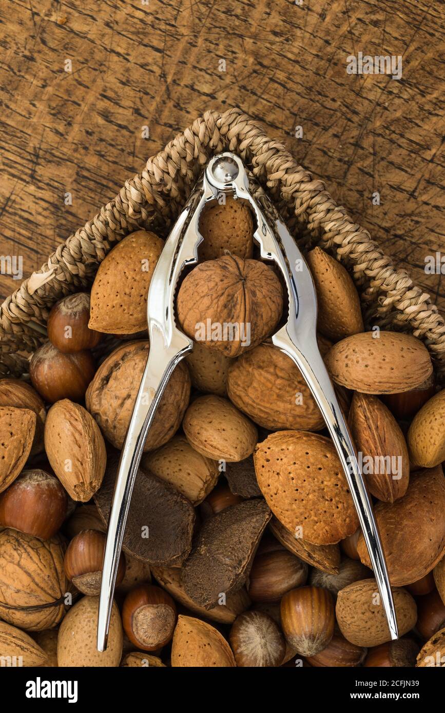 nutcracker e vari noci su fondo tavola di legno Foto Stock