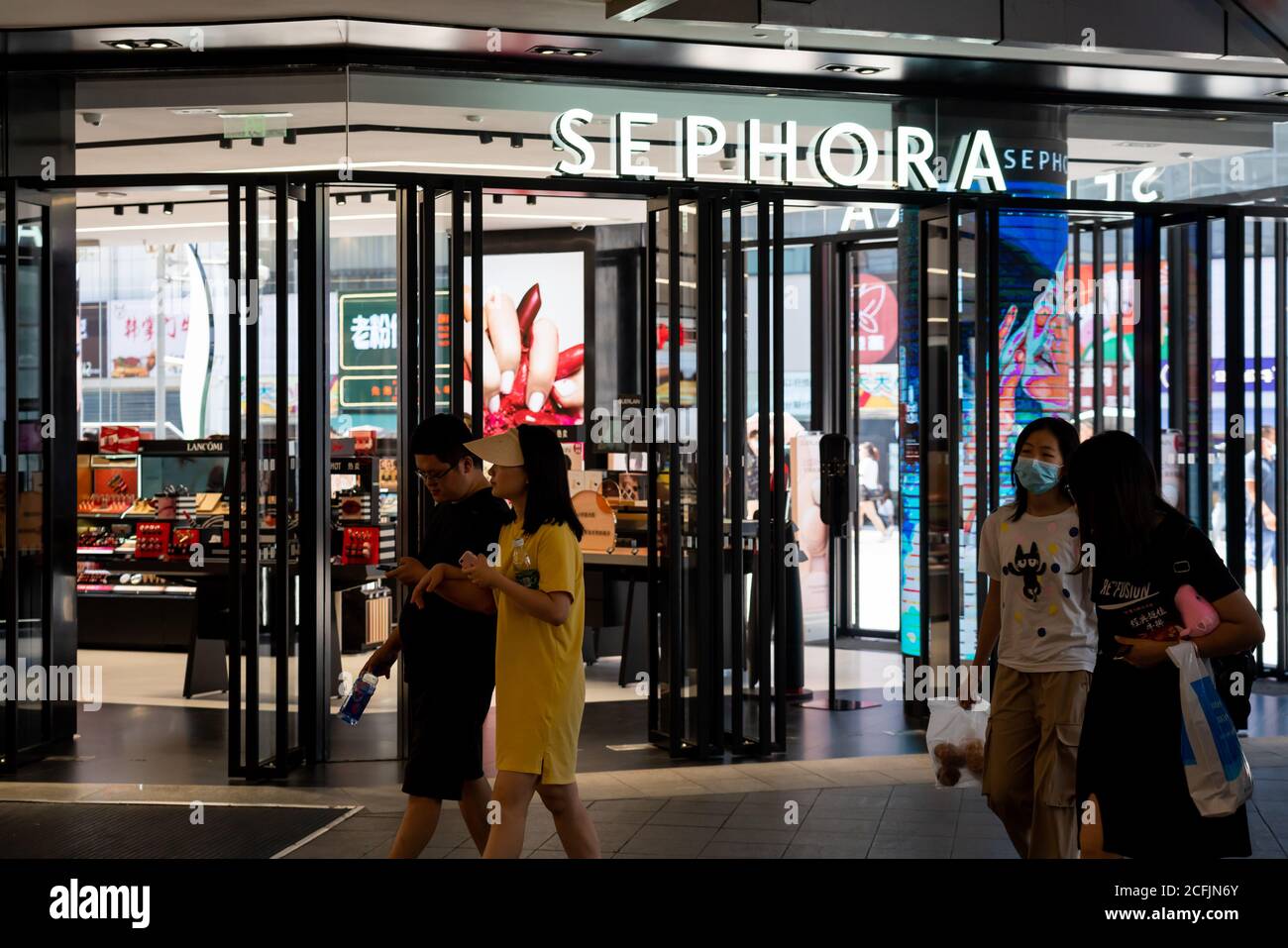 I pedoni attraversano una catena multinazionale francese di cura personale e bellezza, negozio e logo Sephora a Chongqing. Foto Stock