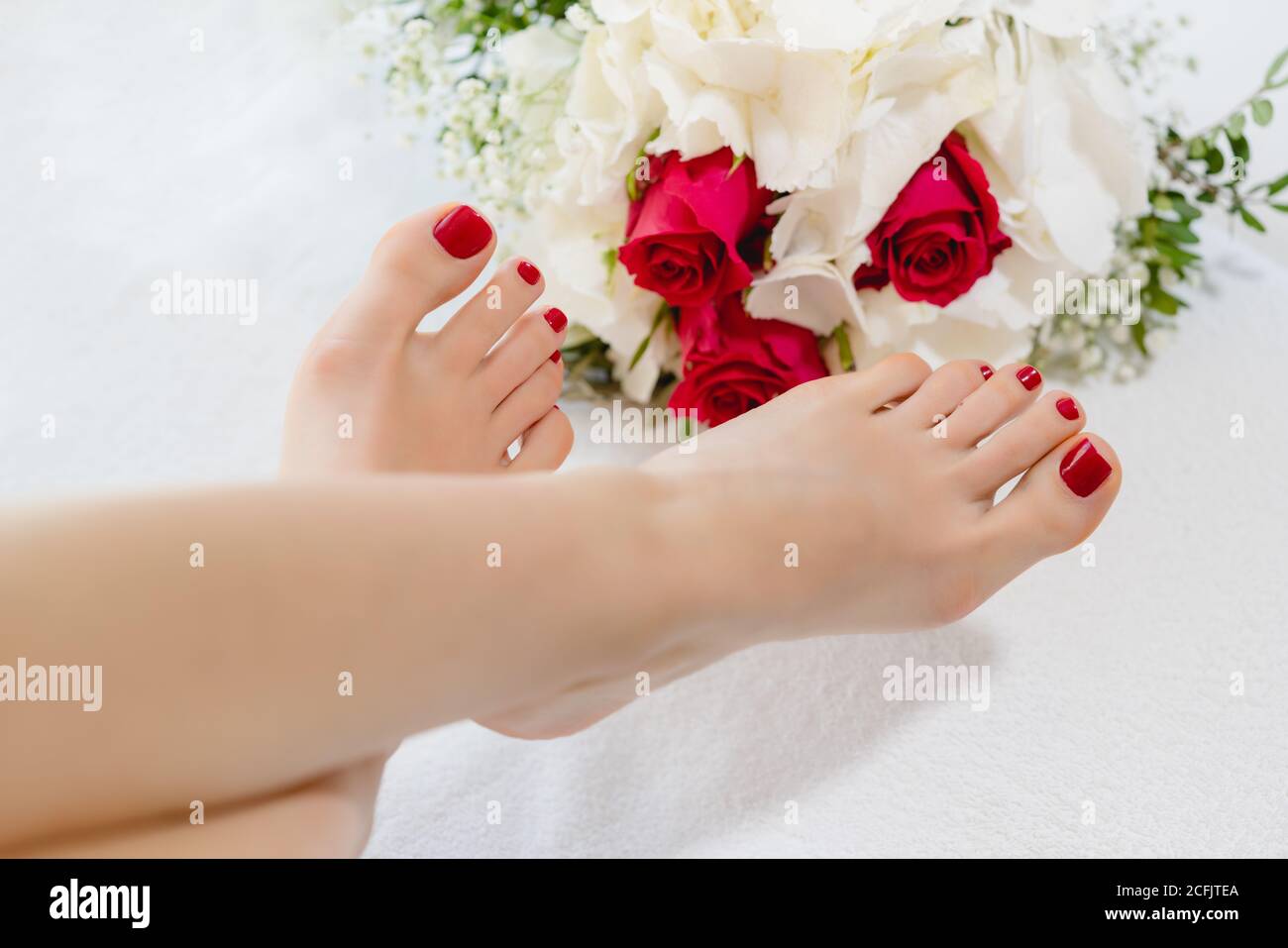 Piedi di donne con le unghie rosse dopo pedicure Foto Stock