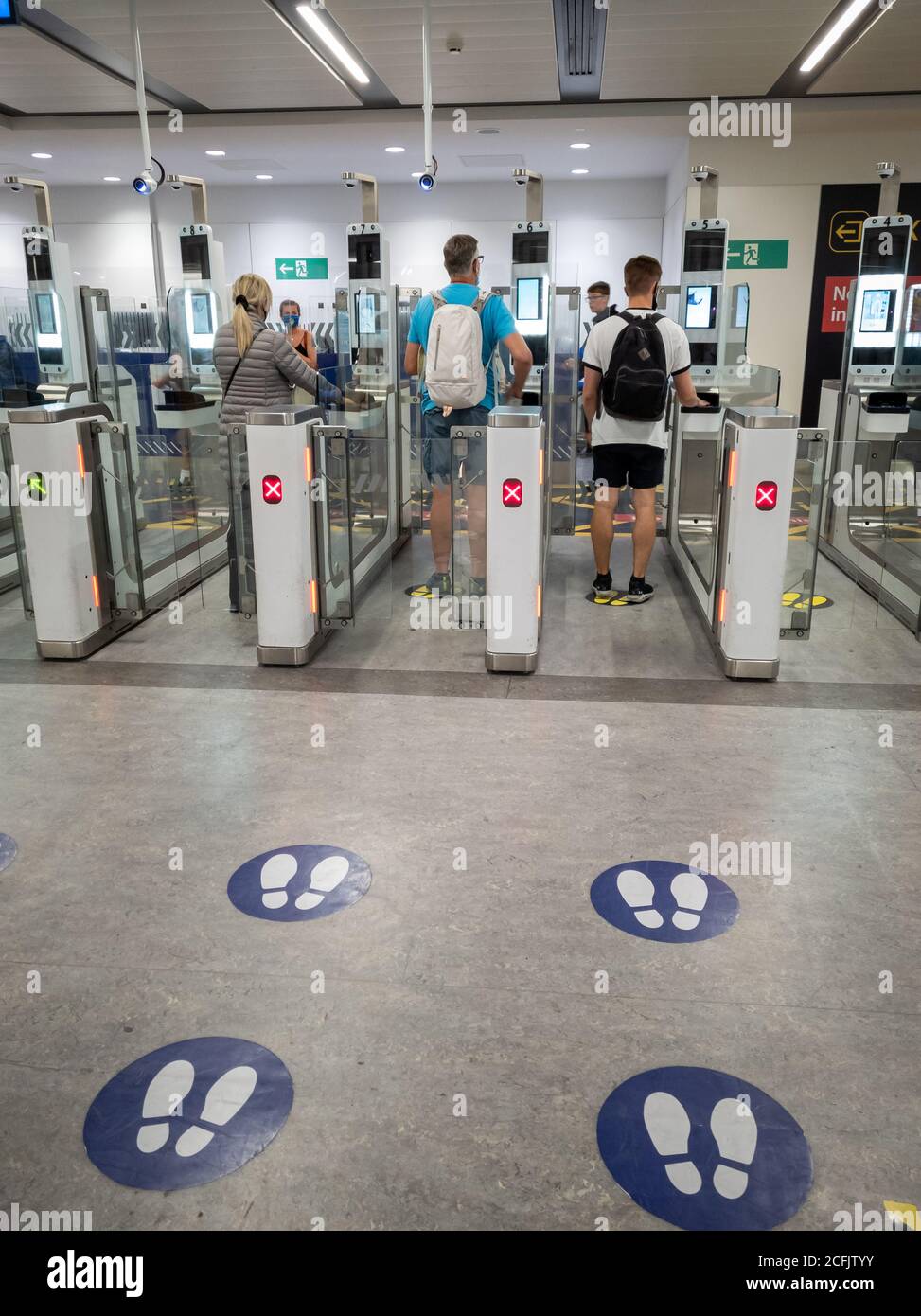 Passeggeri aerei che utilizzano i dispositivi elettronici per l'immigrazione e il controllo dei passaporti al confine con il Regno Unito nell'aeroporto di Gatwick. Foto Stock