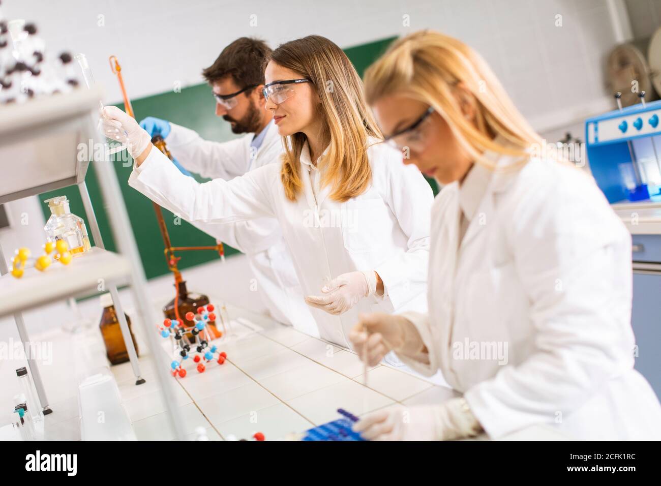 Giovani ricercatori che analizzano i dati chimici in laboratorio Foto Stock