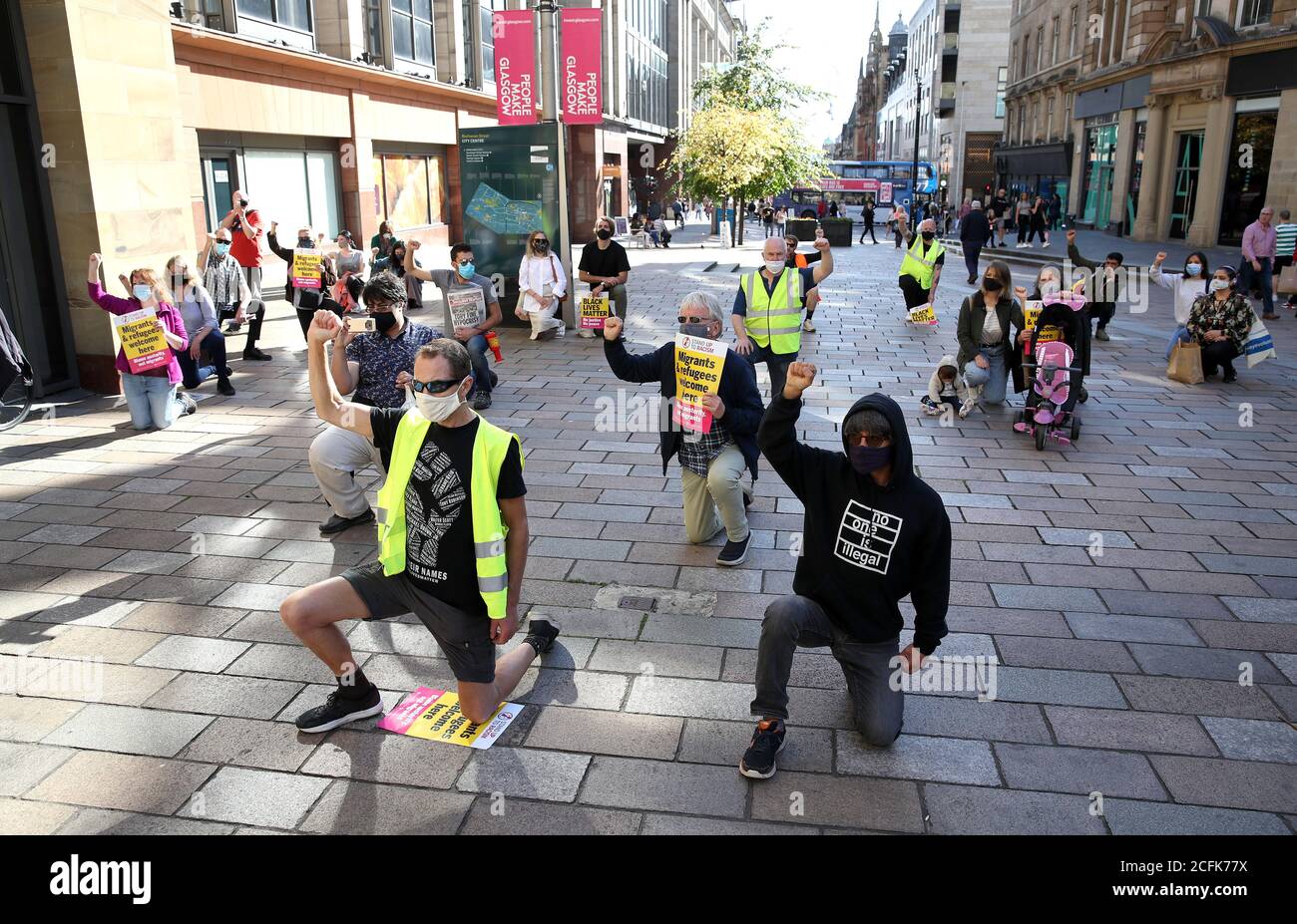 I dimostranti prendono un ginocchio per George Floyd durante un raduno di protesta di accoglienza dei rifugiati e Black Lives Matter a Glasgow organizzato da Stand Up to Racism Scotland. Foto Stock