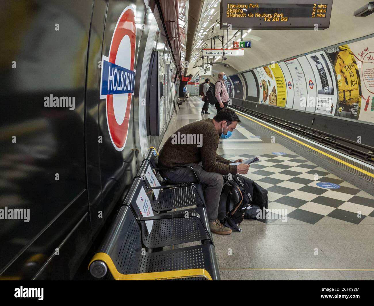 Passeggeri che utilizzano la metropolitana di Londra seguendo le norme di sicurezza del Covid-19 del governo di indossare una copertura di fronte e di distanza sociale. Foto Stock