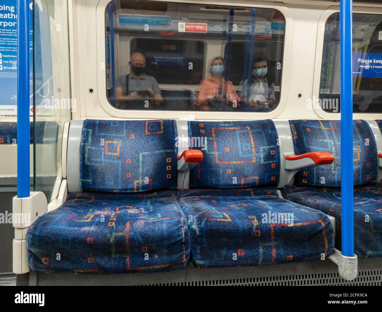 Passeggeri che utilizzano la metropolitana di Londra seguendo le norme di sicurezza del Covid-19 del governo di indossare una copertura di fronte e di distanza sociale. Foto Stock