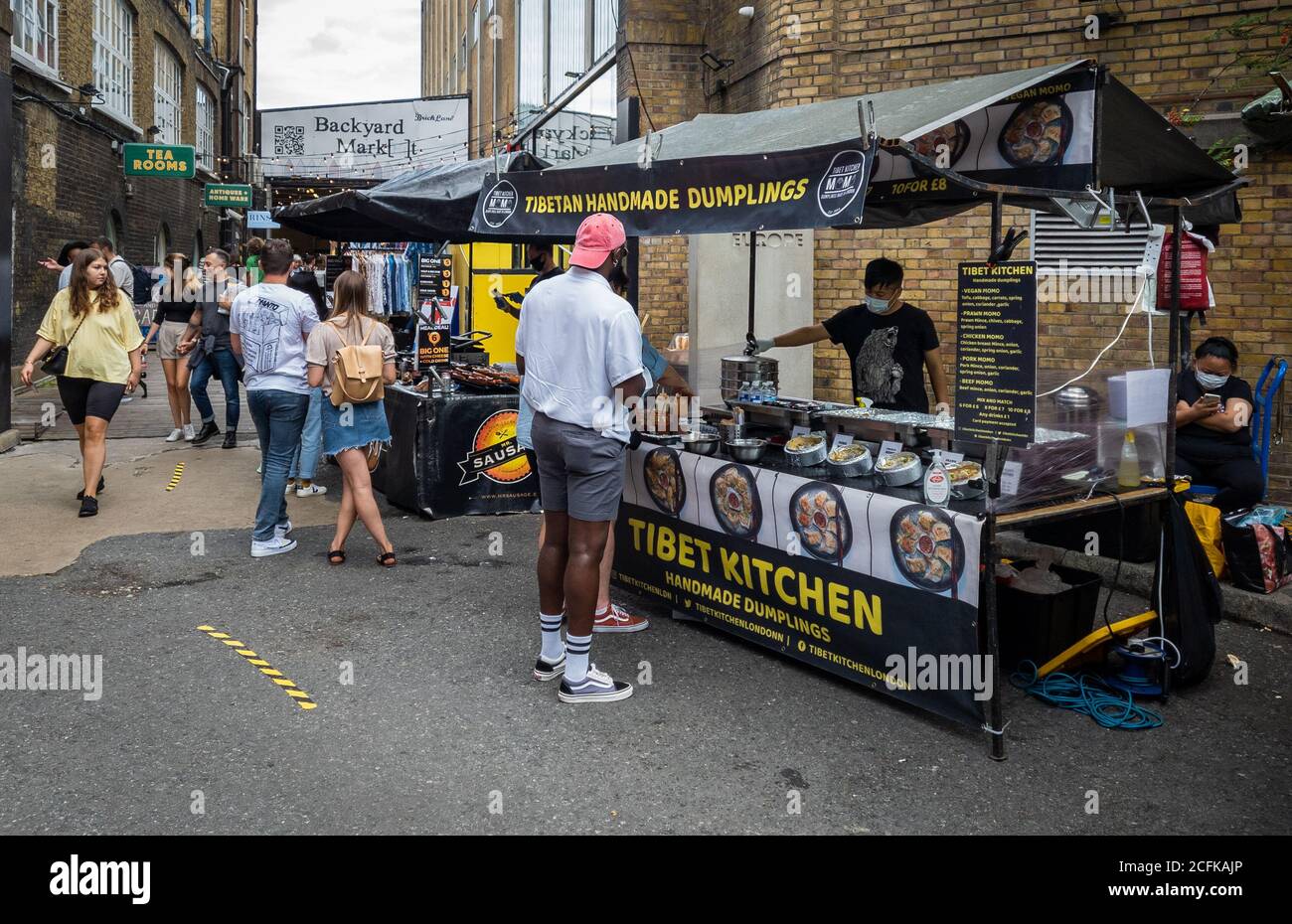 Bancarelle di cibo sul mercato di Brick Lane che offre ai visitatori e ai turisti una varietà di cibi etnici. Foto Stock