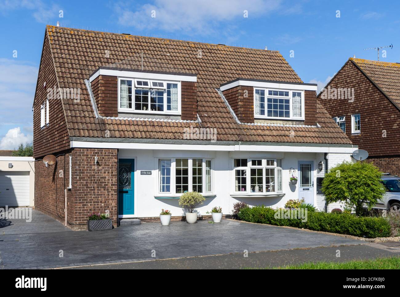 Chalet in stile semi-indipendente casa britannica con grandi finestre Dormer e finestre a prua, nel Sussex occidentale, Inghilterra, Regno Unito. Foto Stock